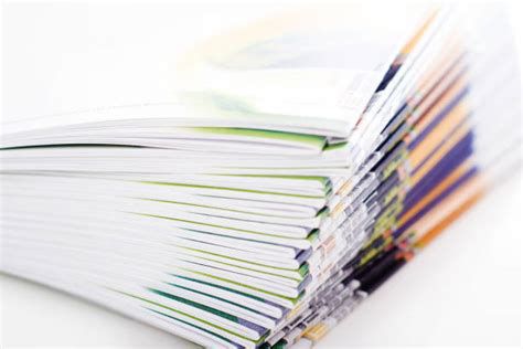 A close-up of a stack of saddle-stitched pamphlets with colorful page edges.